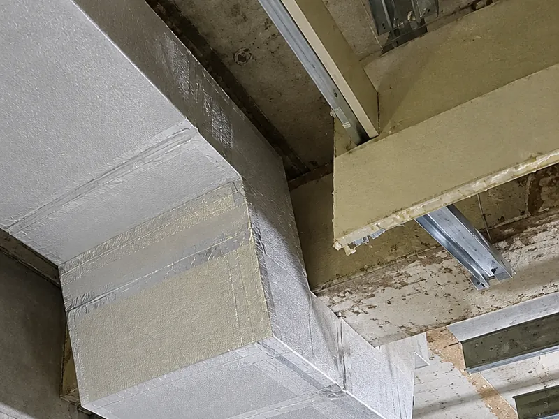 Ducto de aire acondicionado fabricado con paneles, con su codo, colgado del techo