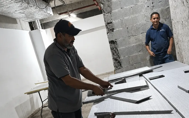 Técnico cortando paneles para fabricar ductos de aire acondicionado
