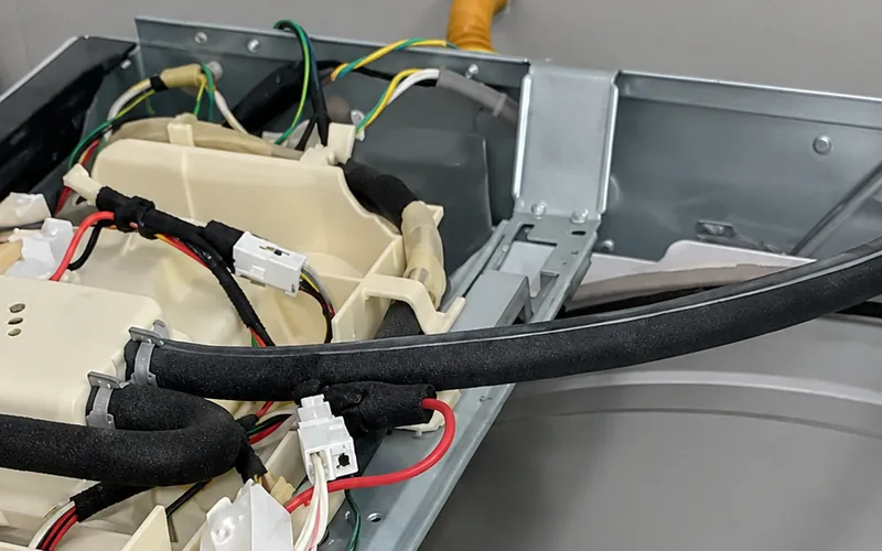 Lavadora abierta, con el cableado a la vista