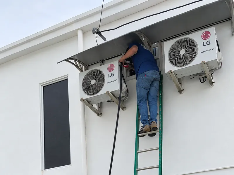 Técnico en una escalera trabajando en splits inverter LG